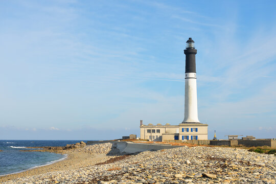 Ile de Sein island rocky coastline of the Atlantic ocean in Brittany, France. Panoramic view. Lighthouse in the background. Idyllic landscape. Travel destinations, tourism, sightseeing, landmarks