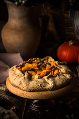 Pumpkin pie with blue cheese at wooden table.