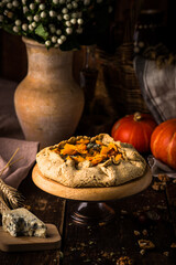 Pumpkin pie with blue cheese at wooden table.