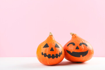 pumpkins with painted faces on a colored background for Halloween.
