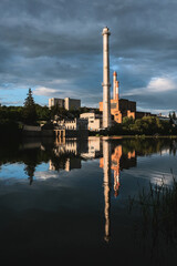 The old factory with smoking chimneys on the banks of the river