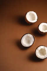 Coconut fruits on brown plain background, abstract food tropical concept, angle view copy space