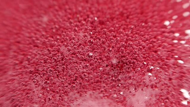 Raspberry syrup. Pink background with bubbling bubbles and raspberries.