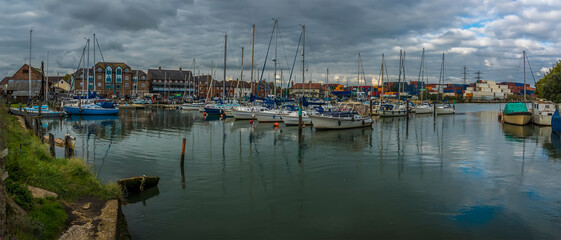 Naklejka na ściany i meble A panorama view of boats moored on the River Test at Eling near Southampton, UK in Autumn