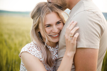 Loving couple on a green lawn. The girl smiles. Emotions.