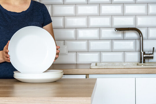 Woman Holds A Dish , Clean Plates. Dishes,