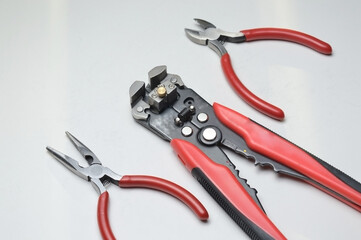 wire stripper, shielded three-core wire and wire cutters on a white background. close-up
