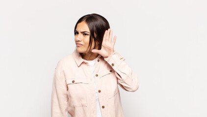 pretty young woman looking serious and curious, listening, trying to hear a secret conversation or...
