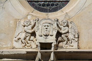 due Angeli reggono il telo della Veronica; scultura sopra il portale gotico della Chiesa dell'Ospedale (Spitalkirche) a Laces (Alto Adige)