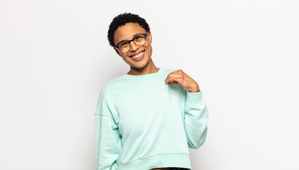 young afro woman looking arrogant, successful, positive and proud, pointing to self