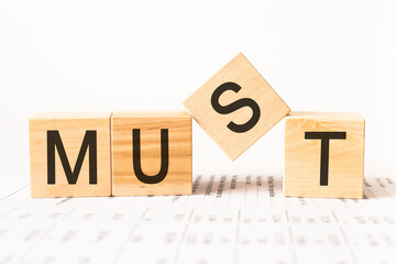 Word must. Wooden small cubes with letters isolated on white background with copy space available.Business Concept image.