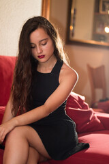Obraz premium Young caucasian woman at the living room with an elegant black dress.