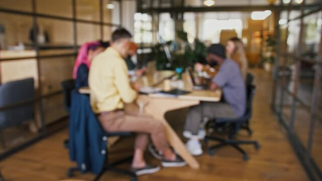 Defocused shot of creative business team working at office, free space, coworking background