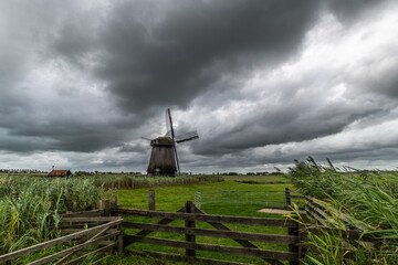 Traditional dutch windmill with clouds above
