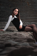 Girl posing with a black and white dress at a rocky cove of the basque coast.