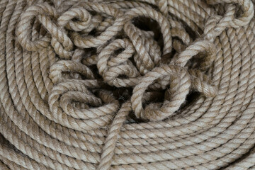 Fototapeta na wymiar Skein of long linen beige rope. Limited depth of field.