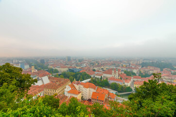 Fototapeta na wymiar Cityscape of Graz from Schlossberg hill on a autumn foggy day, Graz, Styria region, Austria