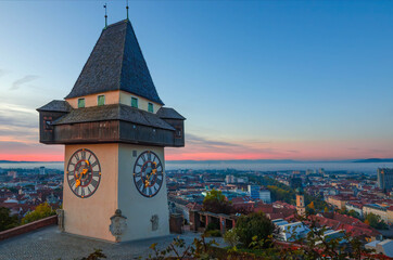 Cityscape of Graz and the famous clock tower on Schlossberg hill, Graz, Styria region, Austria, in autumn, at sunrise