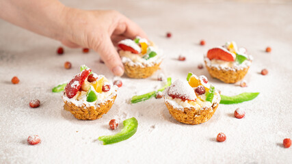 Mums hand taking sweet and healthy homemade oatmeals basket with banana filling and colored fruits. Morning dessert