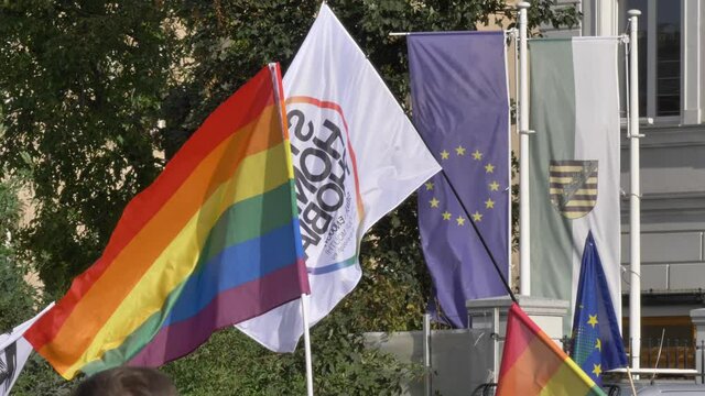 LGBTQ flag with Stop Homophobia an european union flags in slow motion day time