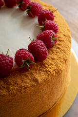  Russian honey cake decorated with raspberries on a wooden background