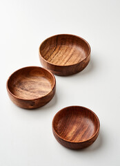 Tres tazones hondos de madera de acacia sobre fondo blanco