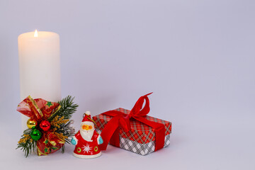 Christmas holidays composition on white background with Christmas decoration, white candle and gifts.  Copy space for text.