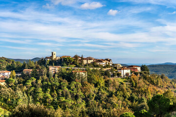Fototapeta na wymiar Scenic view of Monterotondo Marittimo on a hill nestled in the woods in a sunny autumnal day, in Tuscany, Italy