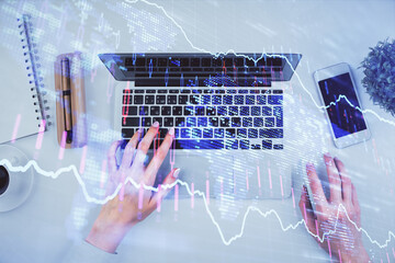 Double exposure of woman hands working on computer and forex chart hologram drawing. Top View. Financial analysis concept.