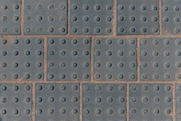 Closeup view of grey wall square tiles dotted background on the public pave way. Surface or texture of old rocks or stones. Stone floor. Texture of facade tiles. Square block concrete background.