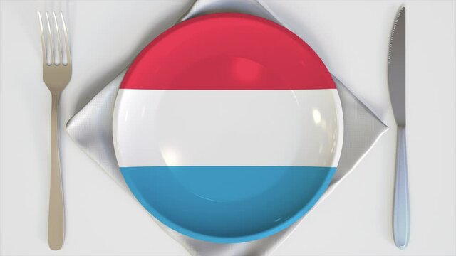 Top-down view of the plate with flag of Luxembourg. National dishes conceptual animation