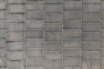 Closeup view of grey wall rectangle tiles background on the public pave way. Surface or texture of old rocks or stones. Stone floor. Texture of facade tiles. Square block concrete background. Brick