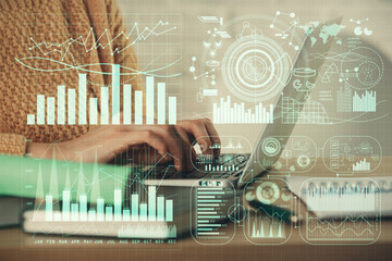 Double exposure of woman hands typing on computer and forex chart hologram drawing. Stock market...