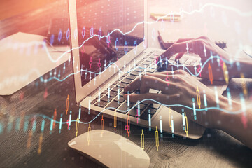 Double exposure of woman hands typing on computer and forex chart hologram drawing. Stock market...