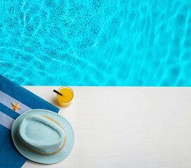 Beach accessories on white wooden deck near swimming pool, flat lay. Space for text