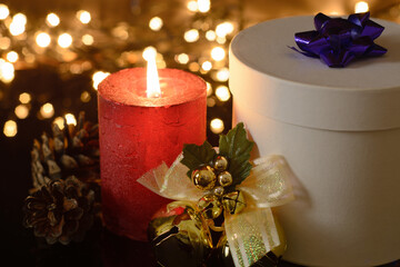 Red christmas candle with gift box  on dark background 