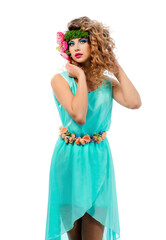 Fototapeta na wymiar Young cute model with bright color makeup in a summer dress on a white background. Fresh flowers in the hairstyle