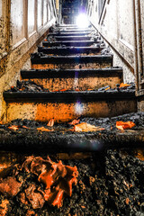Cornwall, Ct, USA The damaged burned steps with autumn leaves in  a wooden house damaged by fire.