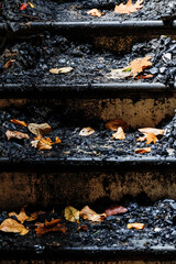 Cornwall, Ct, USA The damaged burned steps with autumn leaves in  a wooden house damaged by fire.
