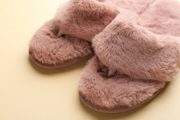 Fototapeta na wymiar Pair of stylish soft slippers on beige background, closeup