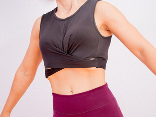 Close-up of sporty young woman doing hypopressive exercise.