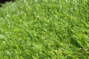 wide view of an artificial grass, detail of the fibers of a green artificial grass