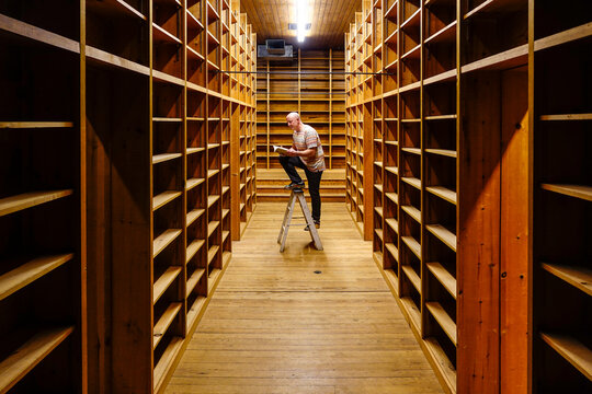 West Cornwall, Ct, USA A Man Stands In An Old And Empty Antiquarian Bookstore Reading One Book.