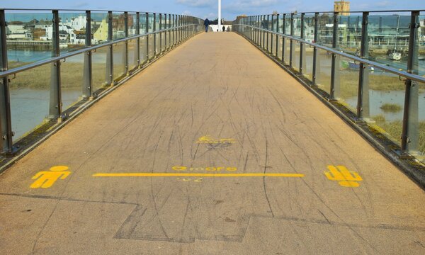 walkway on the bridge. Sign on the footpath two metres distance during Coronavirus 