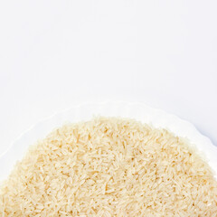 Golden processed rice on white plate close-up. Cereal diet concept. Copy space, top view