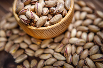 Pistachios in a Cup on a wooden background.  Place for text. Nuts close up