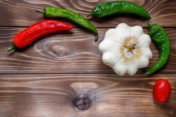Shriveled stale peppers and squash on a wooden background. Flat layout. Space for copying. Ugly food.