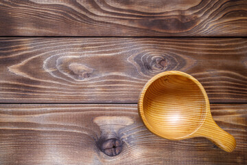 Wooden Cup with spoon on wooden background. Flat layout. Wood texture