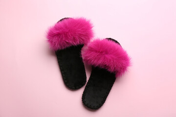 Pair of soft slippers on light pink background, flat lay