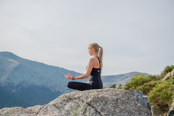 woman meditating yoga mountain postures - obrazy, fototapety, plakaty